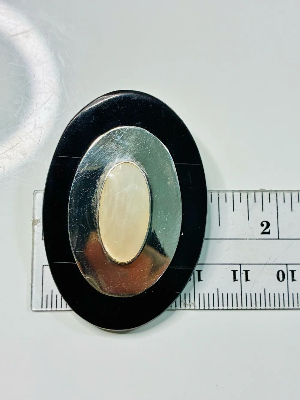 Elevated Simple Black and Silver Oval Brooch with Mother-of-Pearl Center Pendant